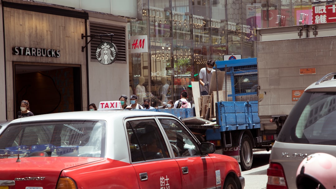 red car parked beside blue truck during daytime