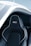 A sleek and modern car seat with black leather upholstery, featuring white stitching and a bold logo on the headrest. The seat is positioned within a partially open car door, revealing a stylish and futuristic design.