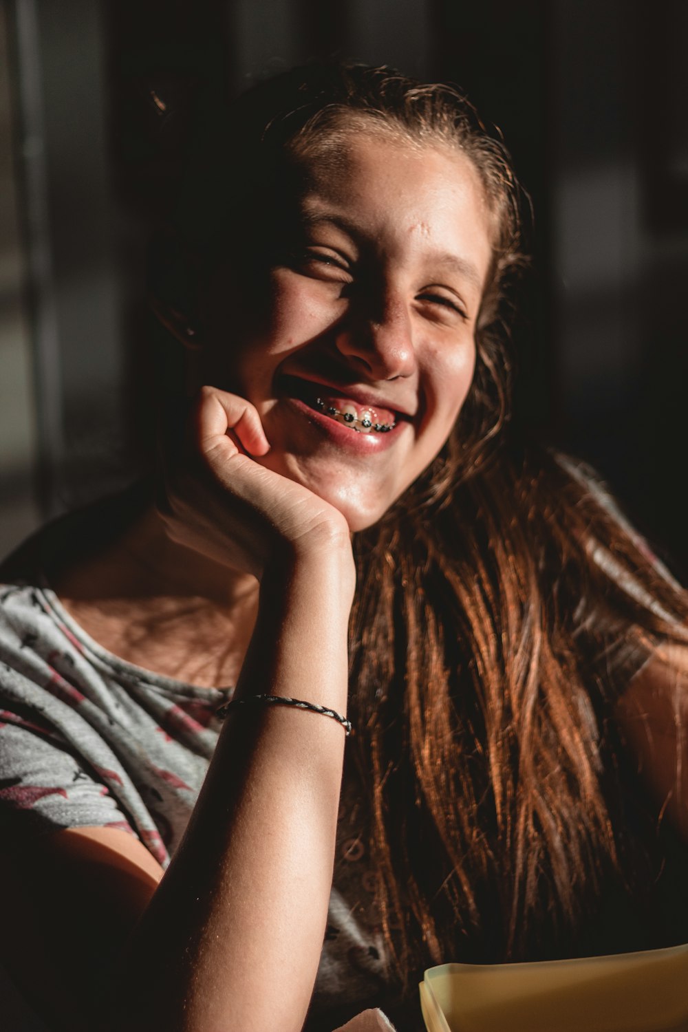 a girl sitting at a table with a plate of food