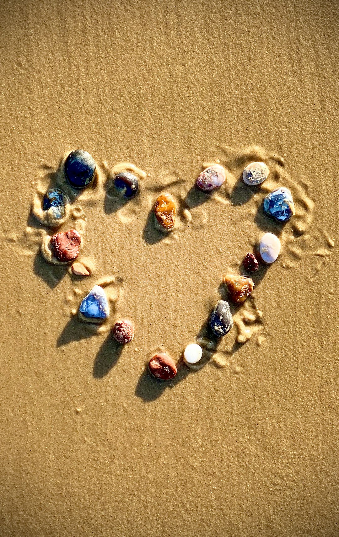 seven assorted color stone on brown sand