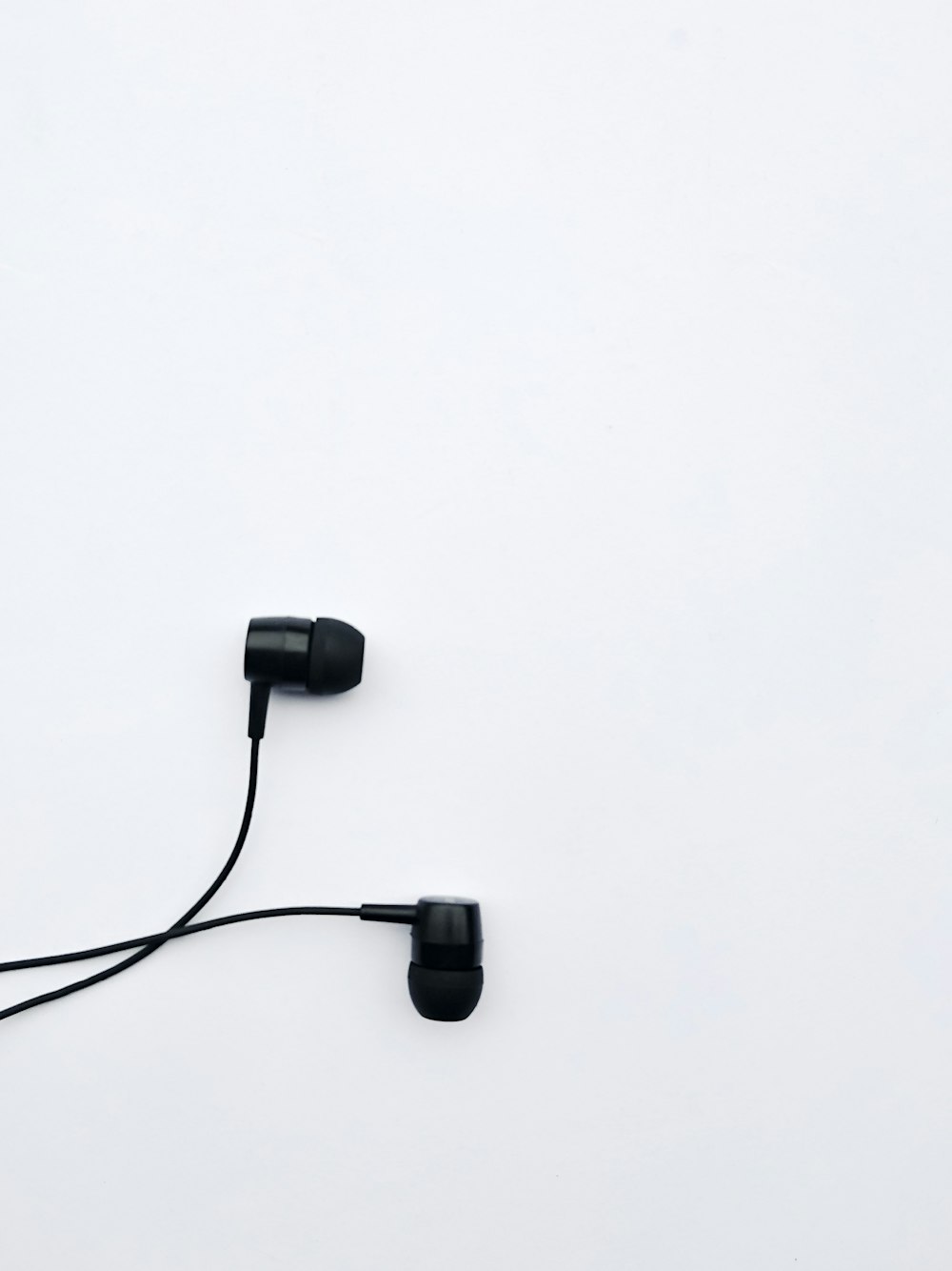 black corded headphones on white table