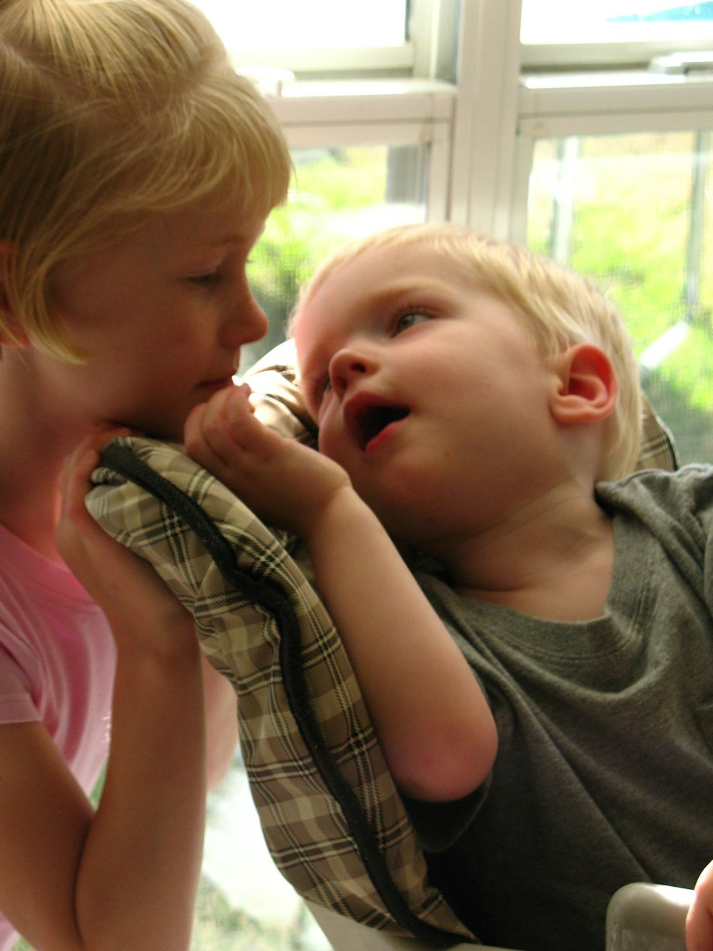 girl in pink tank top kissing boy in gray shirt