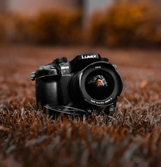 black nikon dslr camera on brown grass