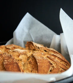 Close-up of rustic artisanal bread with a natural crust on a wooden table.