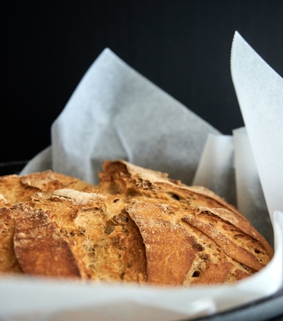 Close-up of a rustic bread loaf with a perfect golden crust resting on a linen cloth.