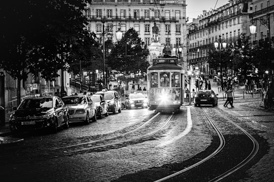 grayscale photo of cars on road near building in Lissabon Portugal