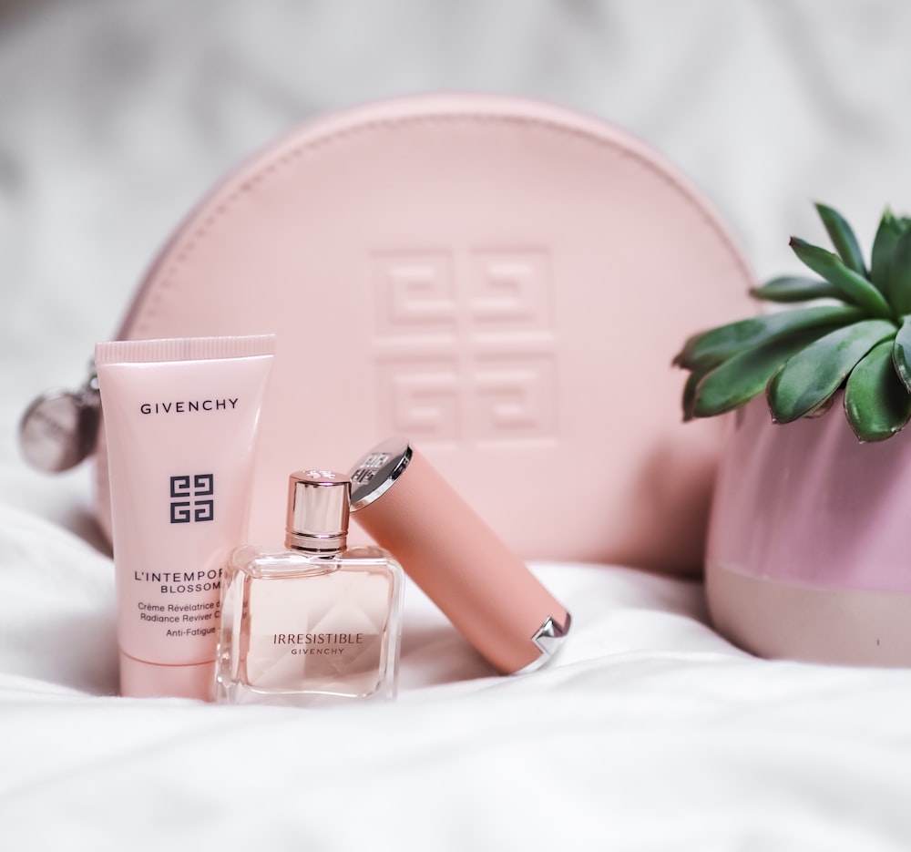 pink perfume bottle on pink leather pouch