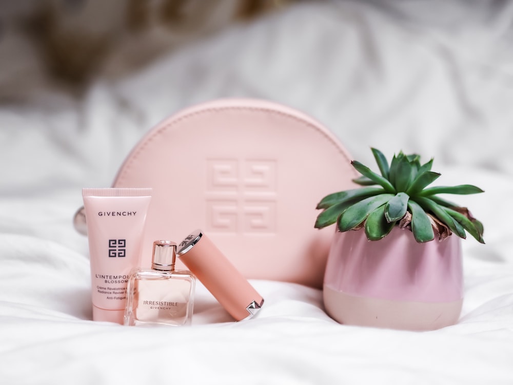 pink and white leather pouch with green plant