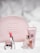 A collection of Givenchy beauty products is arranged neatly. A pink embossed makeup bag is in the background. In the foreground, a pink lipstick in a shiny silver tube is placed next to a clear glass perfume bottle labeled 'Irresistible Givenchy' and a pink tube of skincare product.
