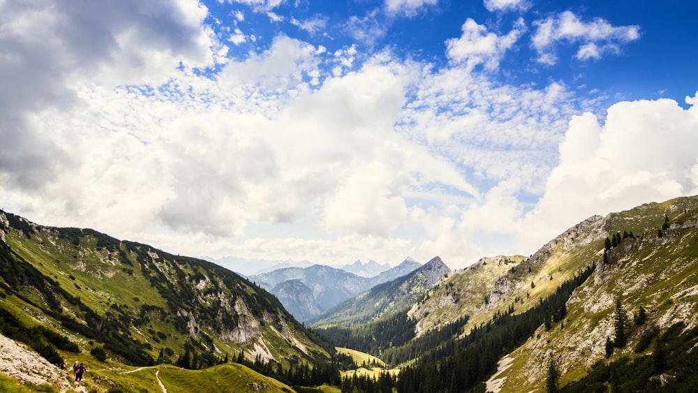 green mountains under white clouds and blue sky during daytime