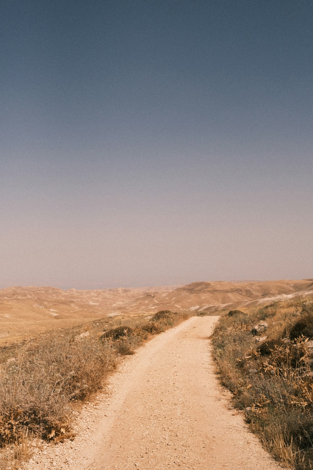 brown sand field under blue sky during daytime