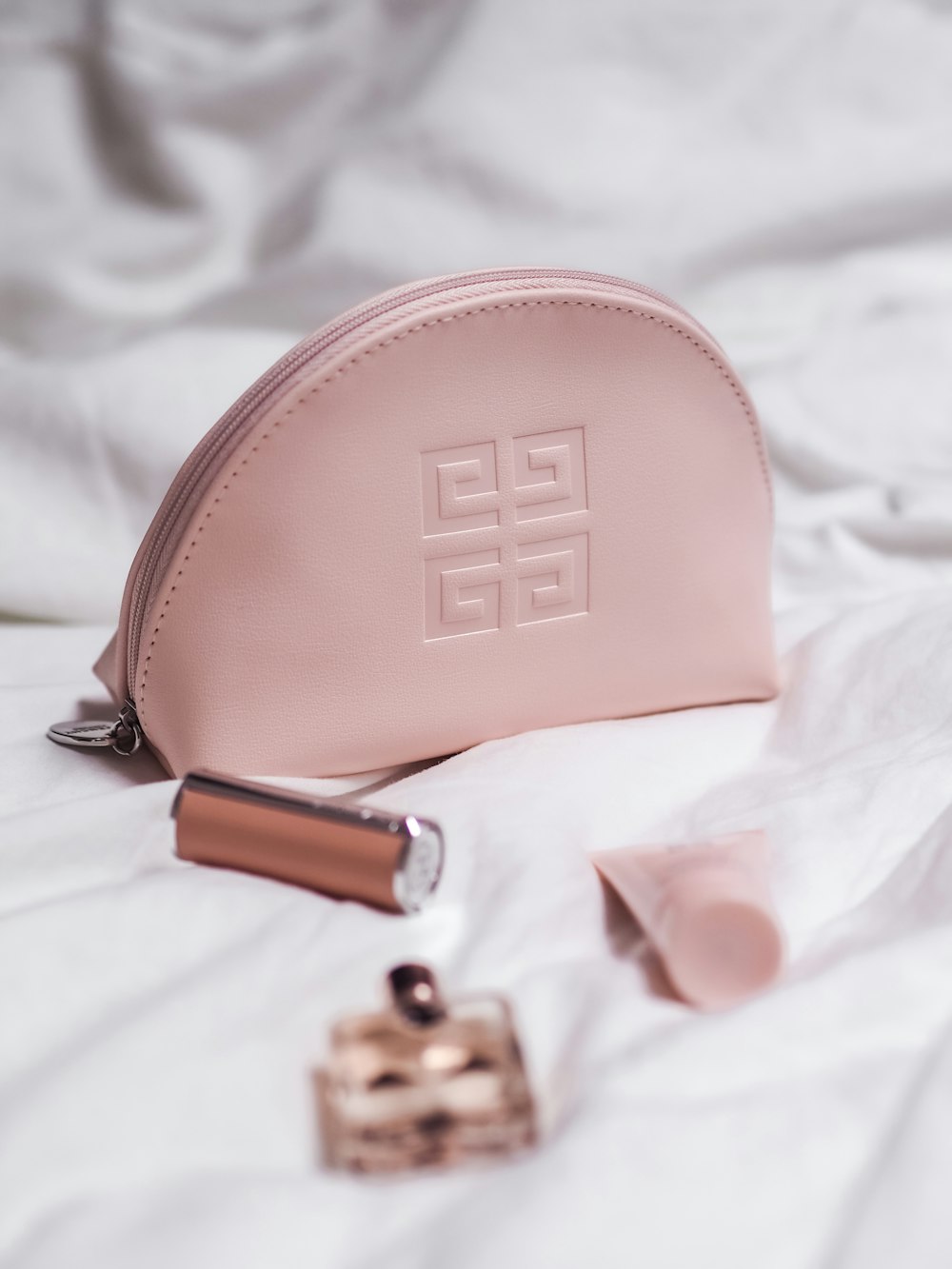 pink leather sling bag on white textile