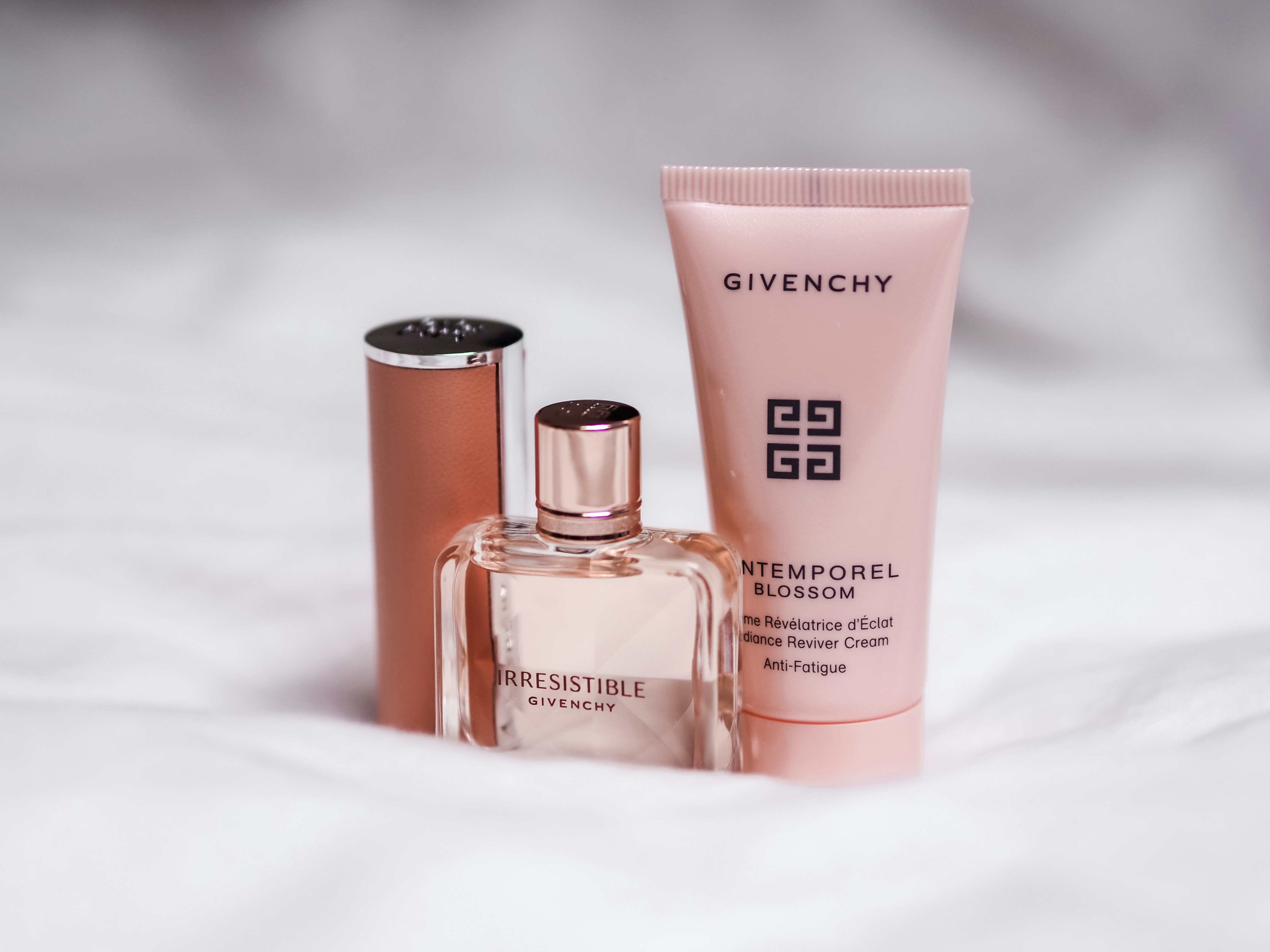 a couple of bottles of perfume sitting on top of a bed