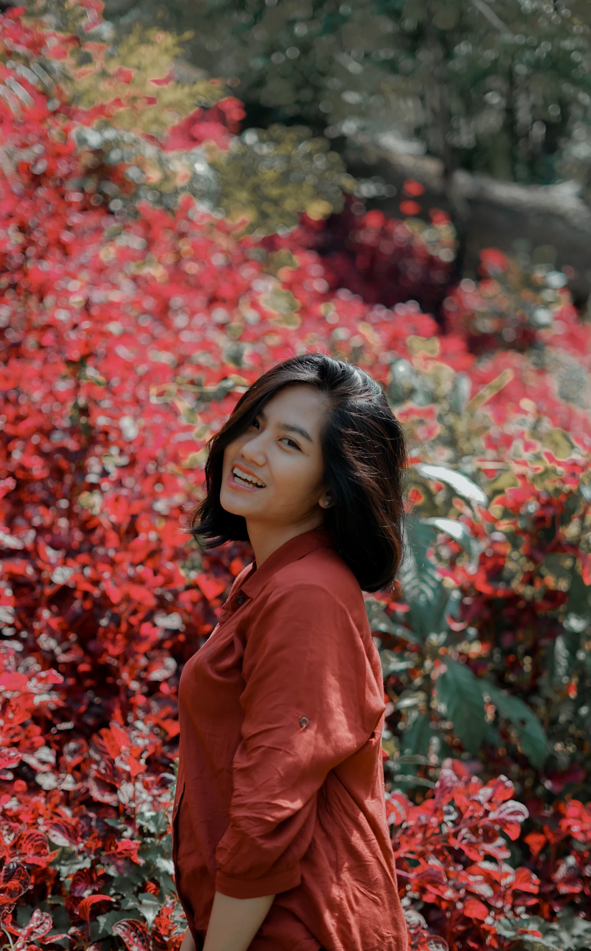 Portrait of a community member smiling warmly in a community garden setting