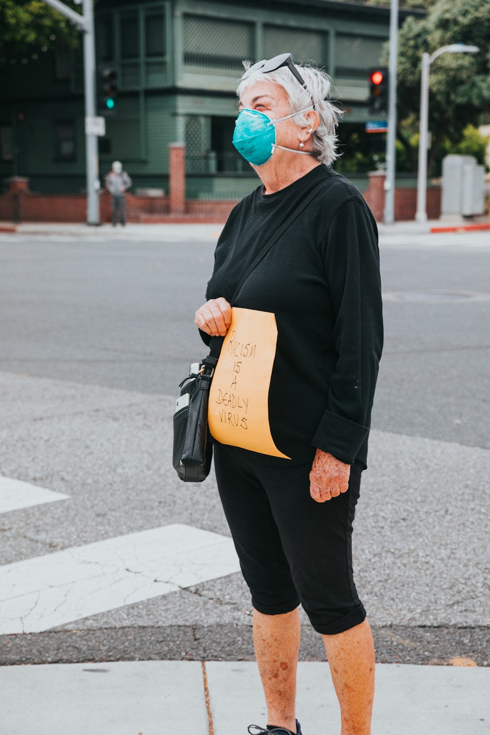 man in black jacket and black pants walking on sidewalk during daytime