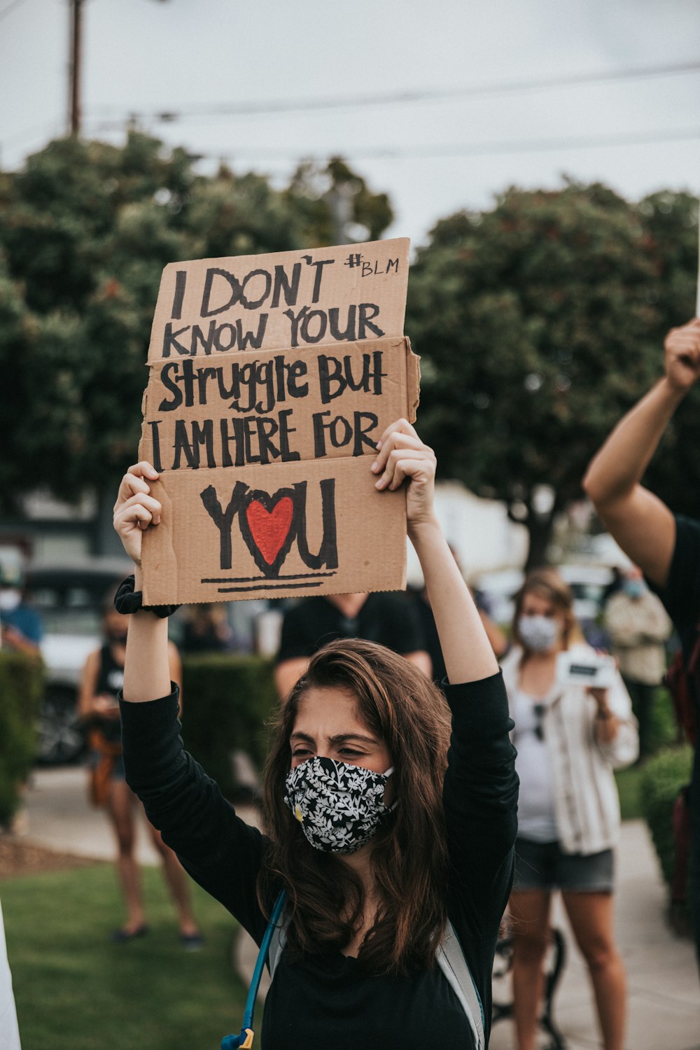 Une femme tenant une pancarte qui dit Je ne connais pas ton combat mais je