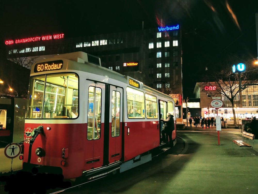 red and white tram on road during nighttime