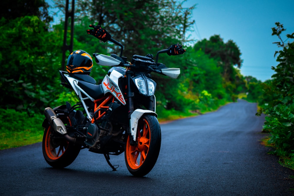 Motocicleta negra y naranja en la carretera durante el día