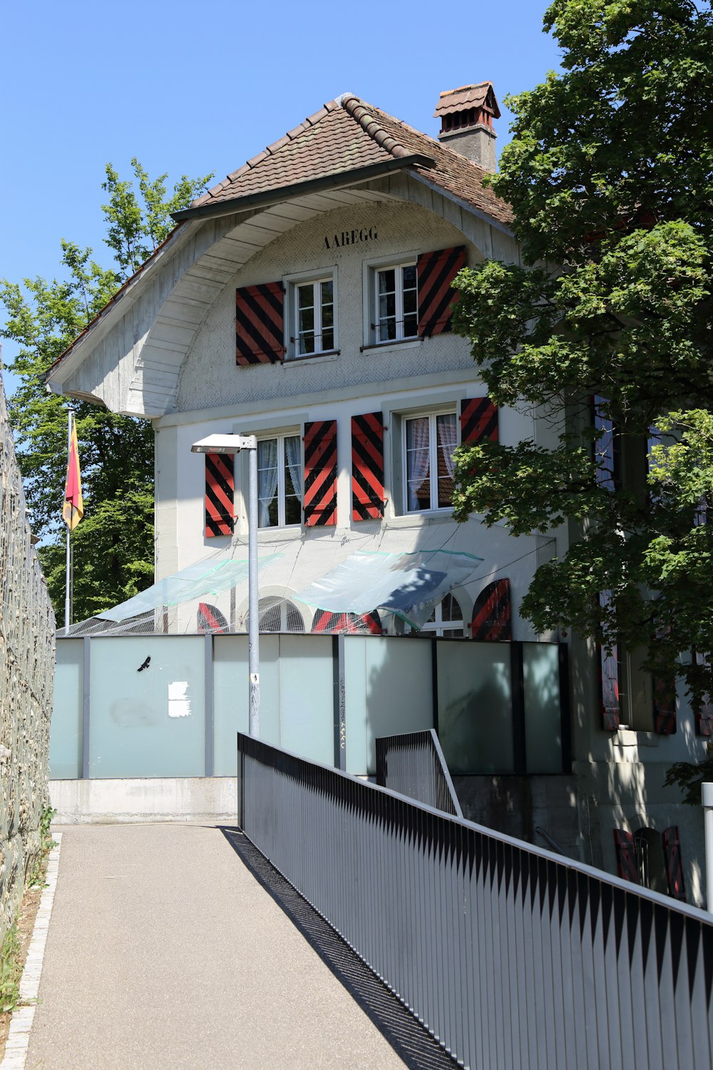 white and red wooden house near green trees during daytime