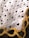 A fabric designed with repeating text 'I ❤️ JESUS' interspersed with black heart icons. A decorative pattern with yellow and orange chains is visible at the lower corner.