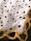 A fabric designed with repeating text 'I ❤️ JESUS' interspersed with black heart icons. A decorative pattern with yellow and orange chains is visible at the lower corner.