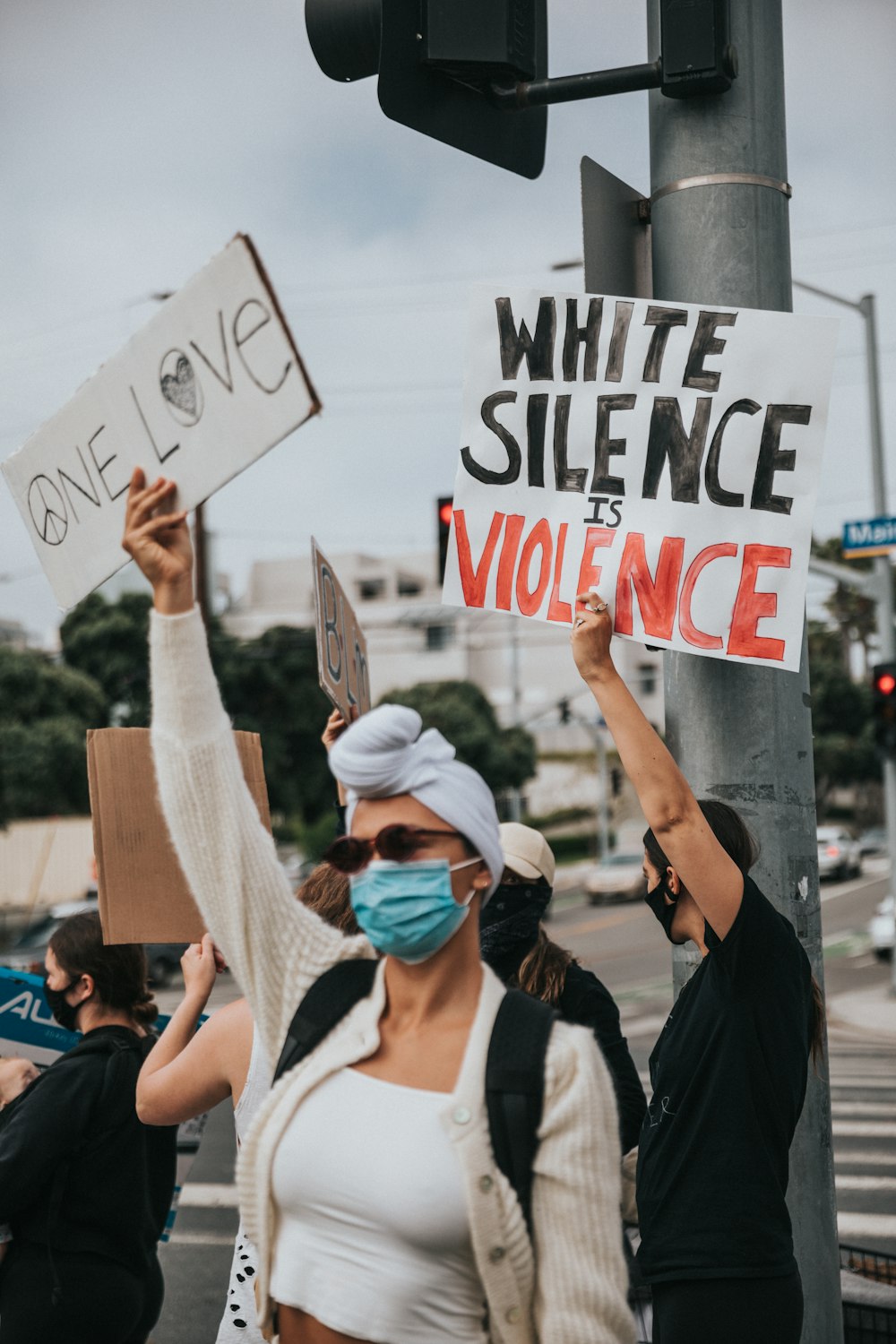 woman in white tank top holding white and red happy birthday signage