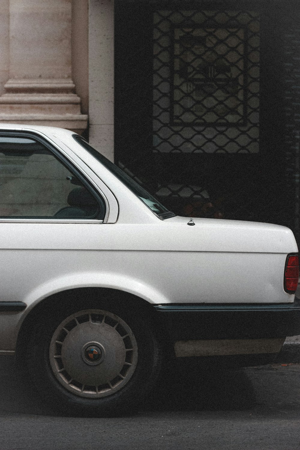 white car near brown brick wall