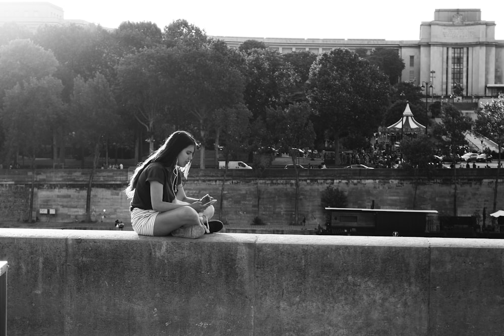 woman in black tank top and black shorts sitting on concrete bench