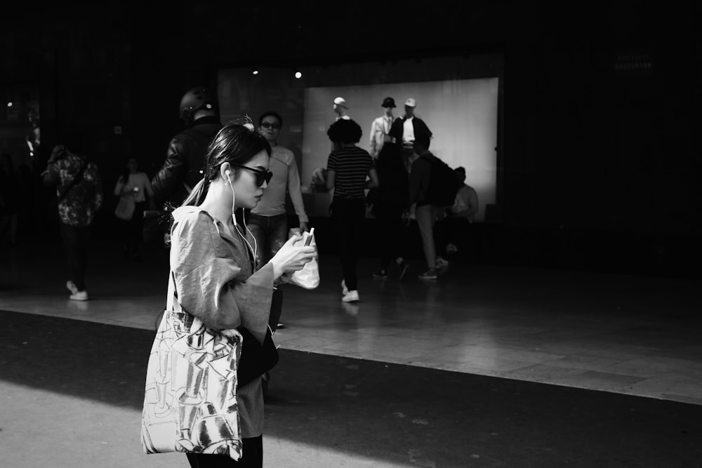 grayscale photo of woman in white long sleeve shirt and black pants