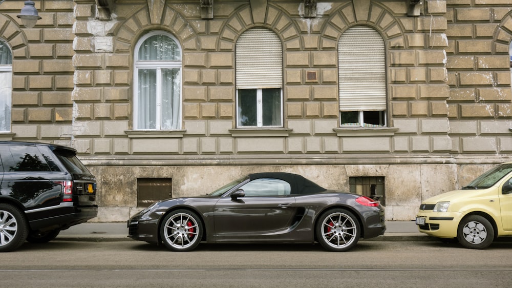 Porsche 911 preto estacionado em frente ao edifício de concreto marrom