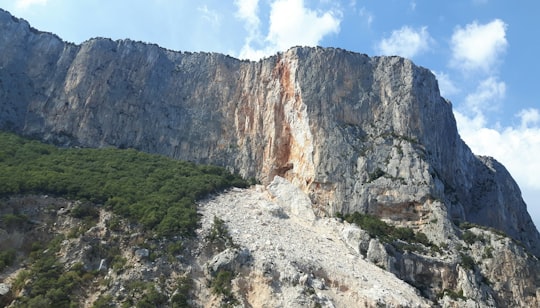 rocky mountain under cloudy sky during daytime in Sardinia Italy