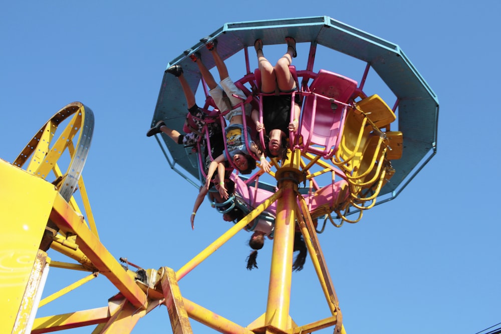 man in red jacket riding yellow and red roller coaster