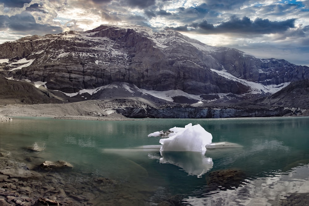 lake near mountain range under cloudy sky during daytime