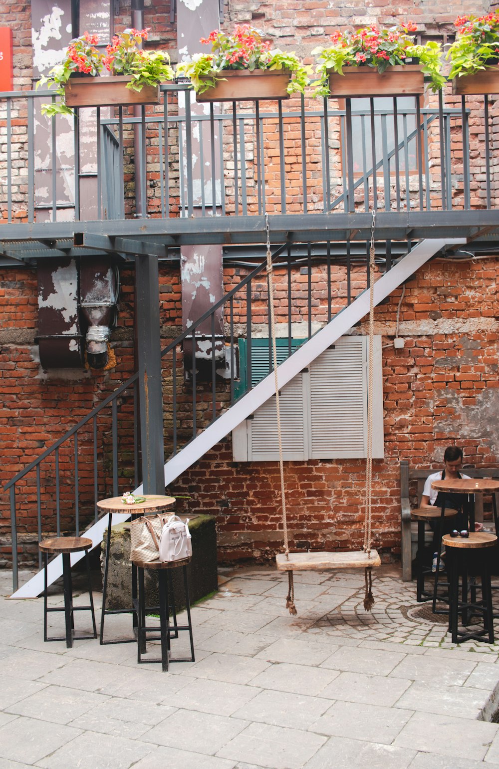 2 person sitting on chair near brown brick building during daytime