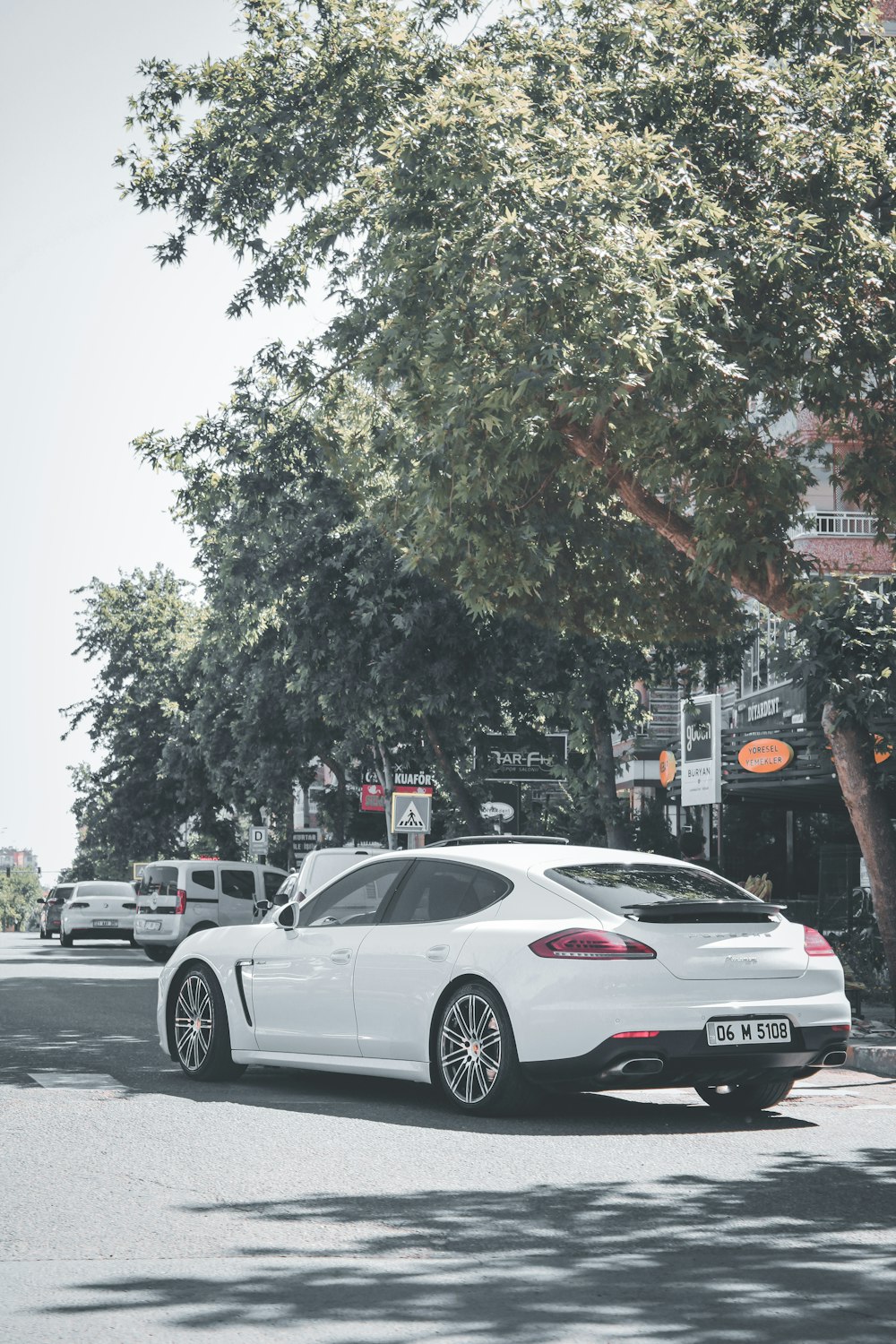 white sedan on road during daytime