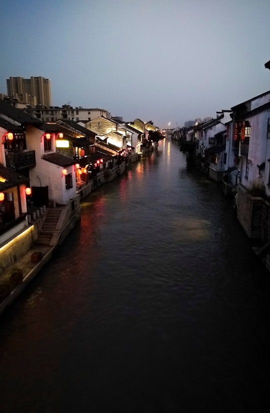 river between houses during night time in Wuxi China