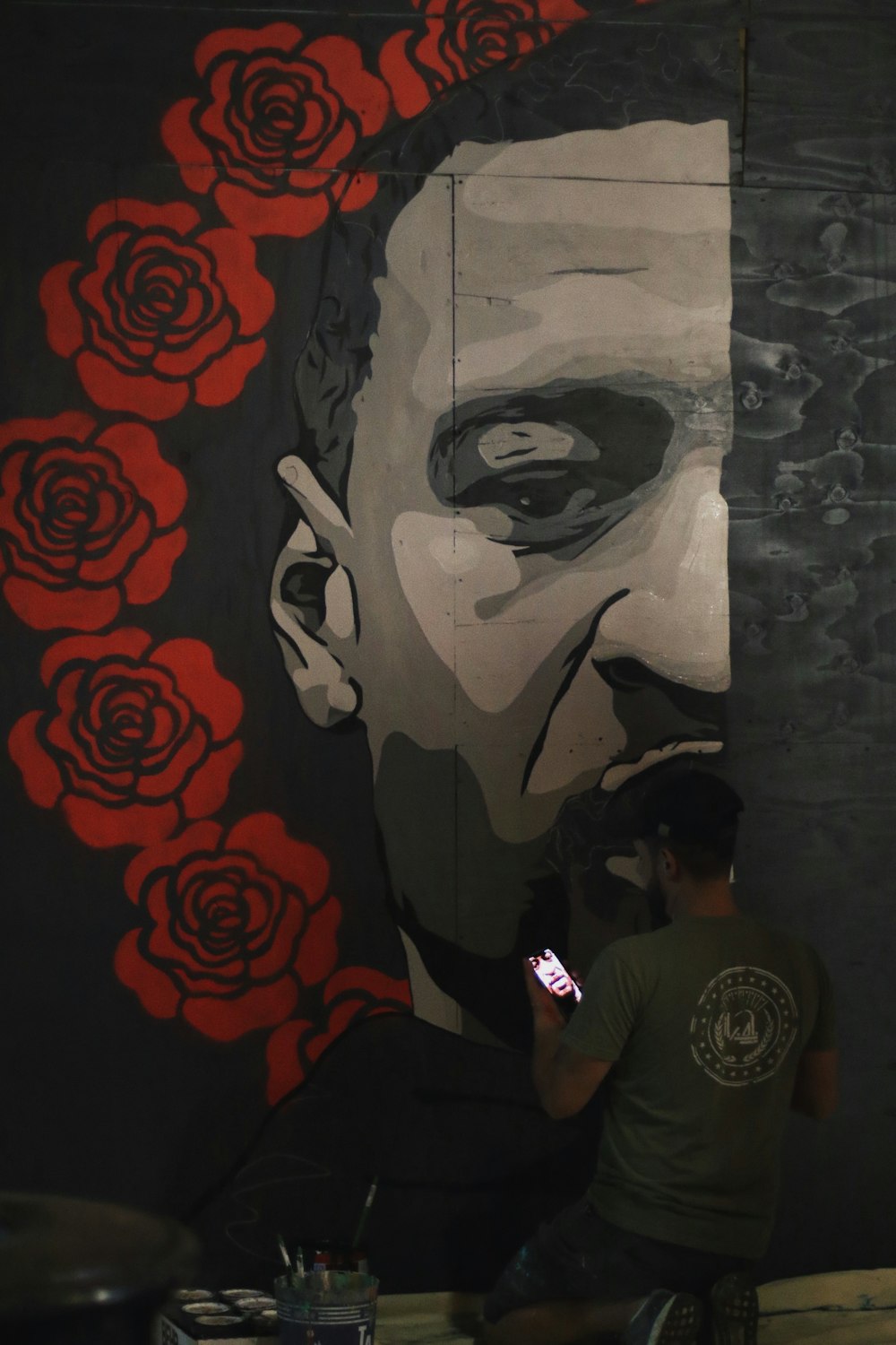 man in black crew neck t-shirt standing beside wall with graffiti