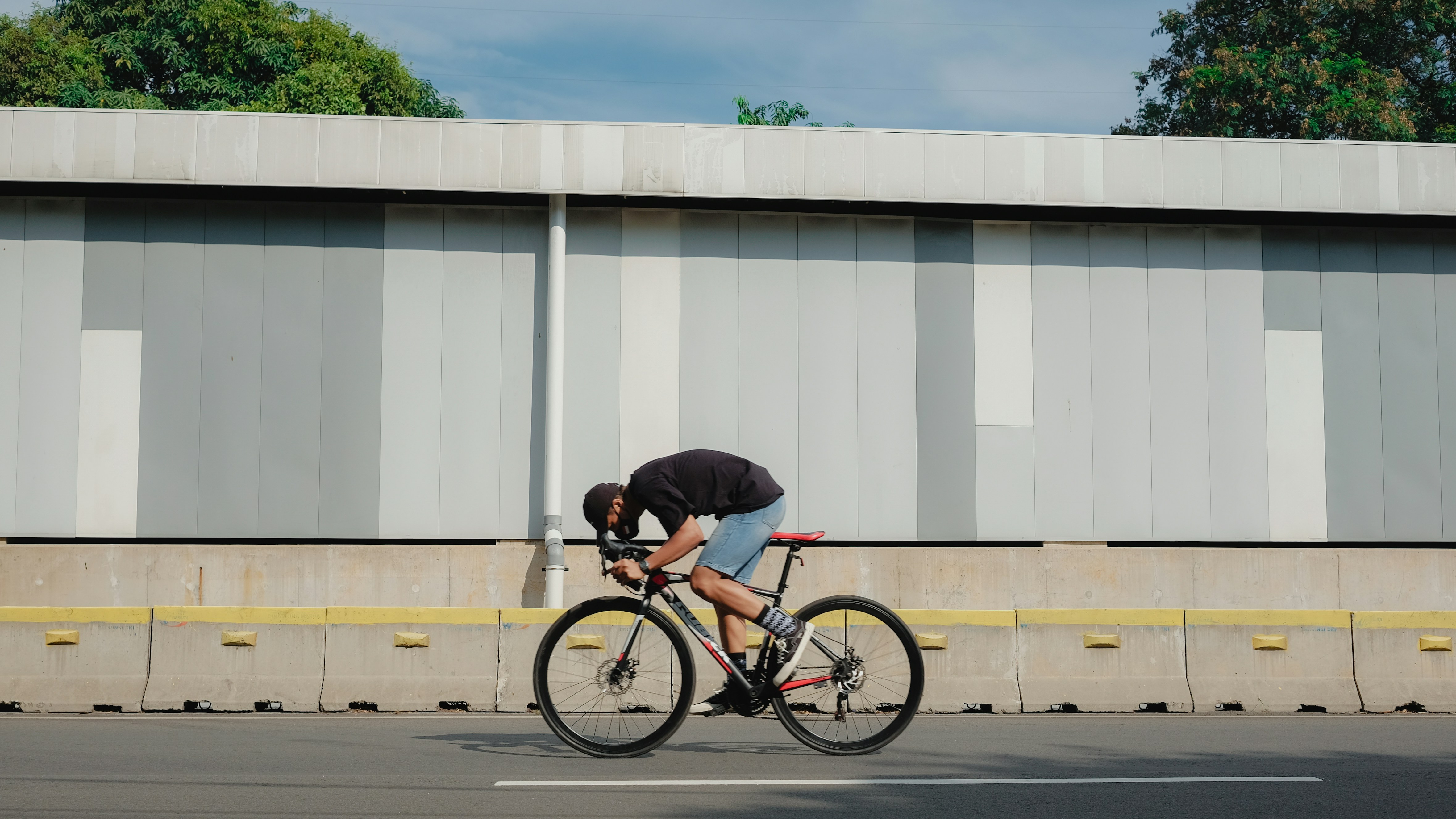 man in black t-shirt riding bicycle on road during daytime