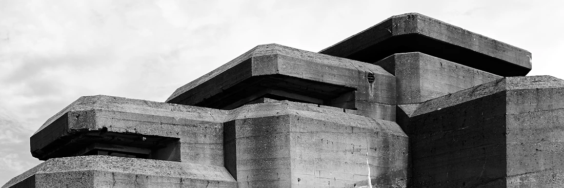 A weathered concrete bunker against a white sky