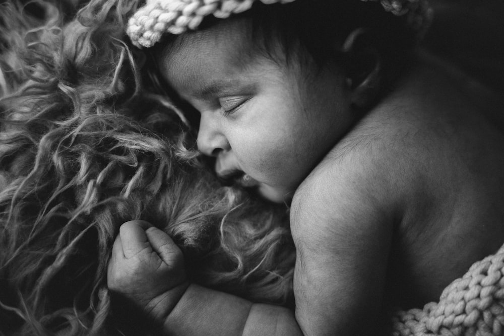 grayscale photo of woman kissing baby