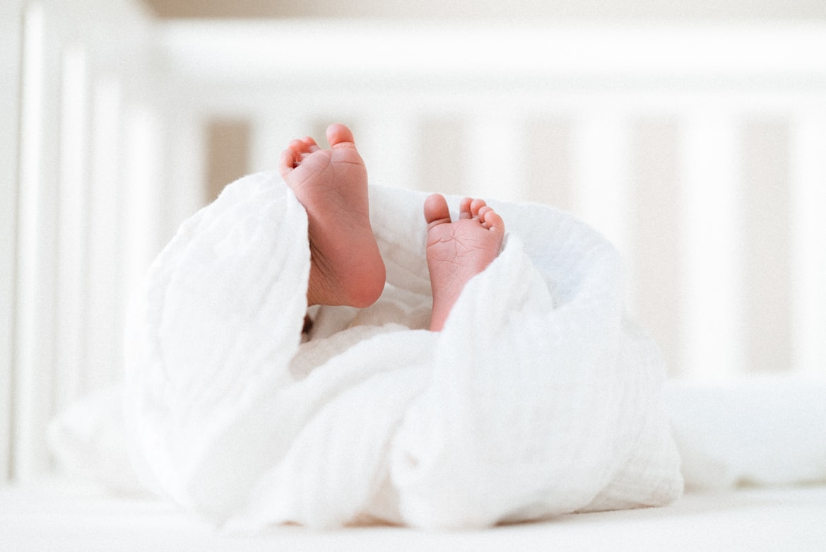 newborn baby’s feet sticking out of blanket
