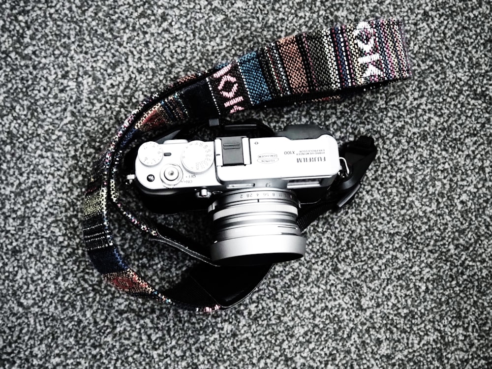 black and silver dslr camera on black and red strap