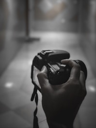 A candid shot of a photographer adjusting a camera in front of a stylish hotel lobby, capturing natural light and atmosphere.