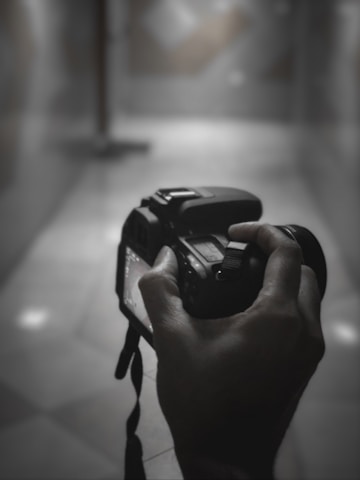 A candid shot of a photographer adjusting a camera in front of a stylish hotel lobby, capturing natural light and atmosphere.