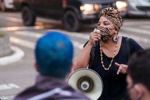 A determined advocate speaking through a bullhorn on a busy Georgia street.