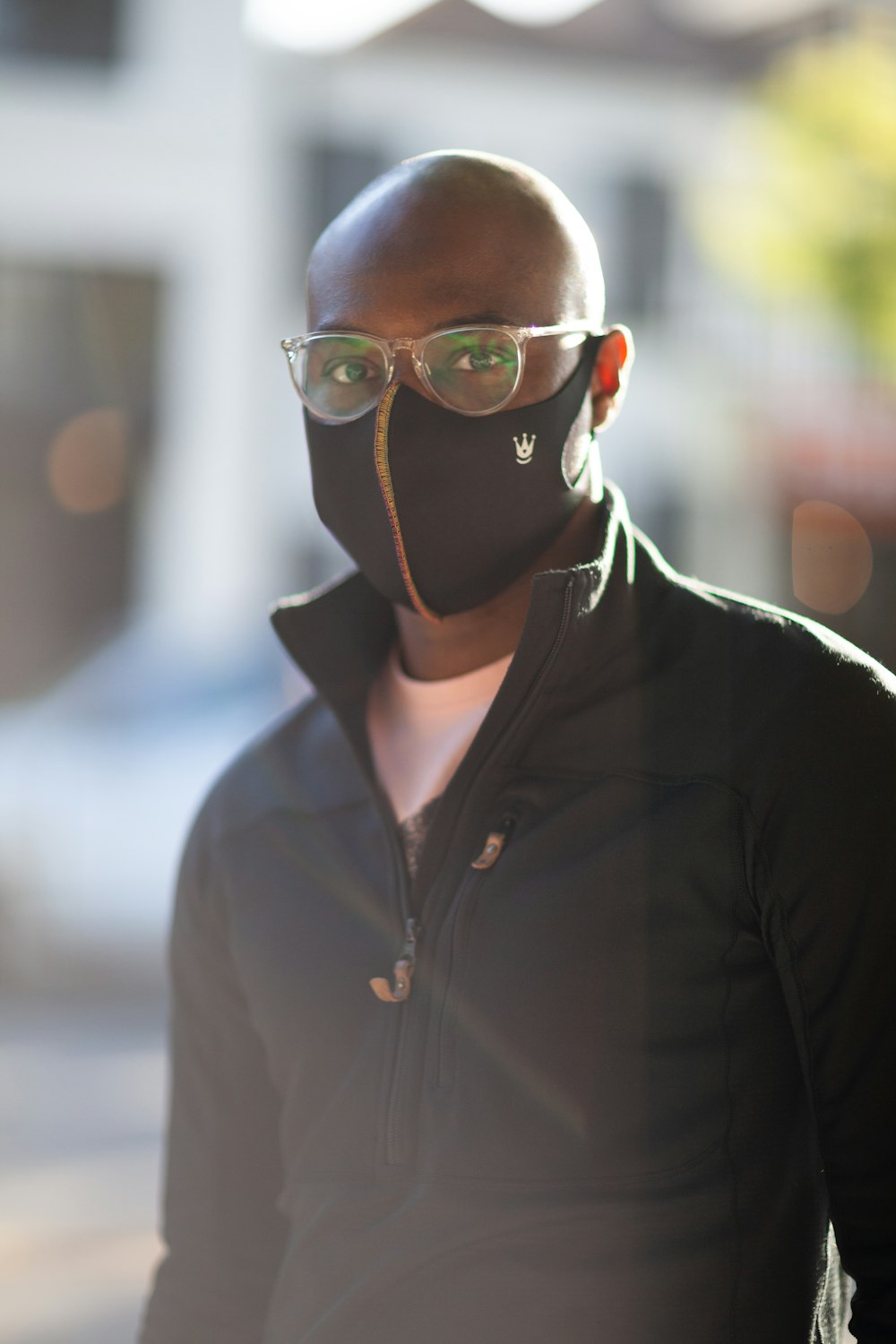 man in black zip up jacket wearing black framed eyeglasses