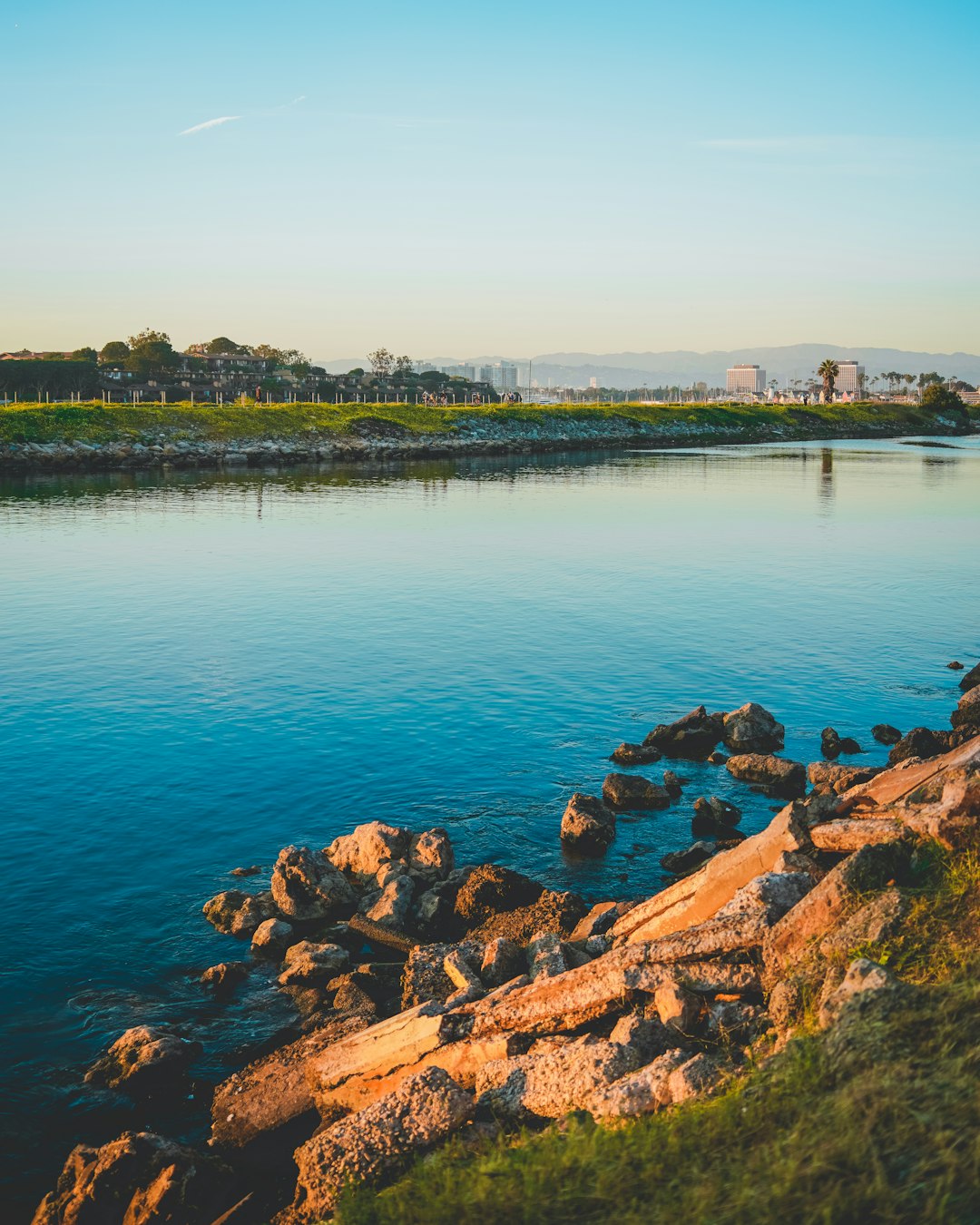 brown rocks beside body of water during daytime