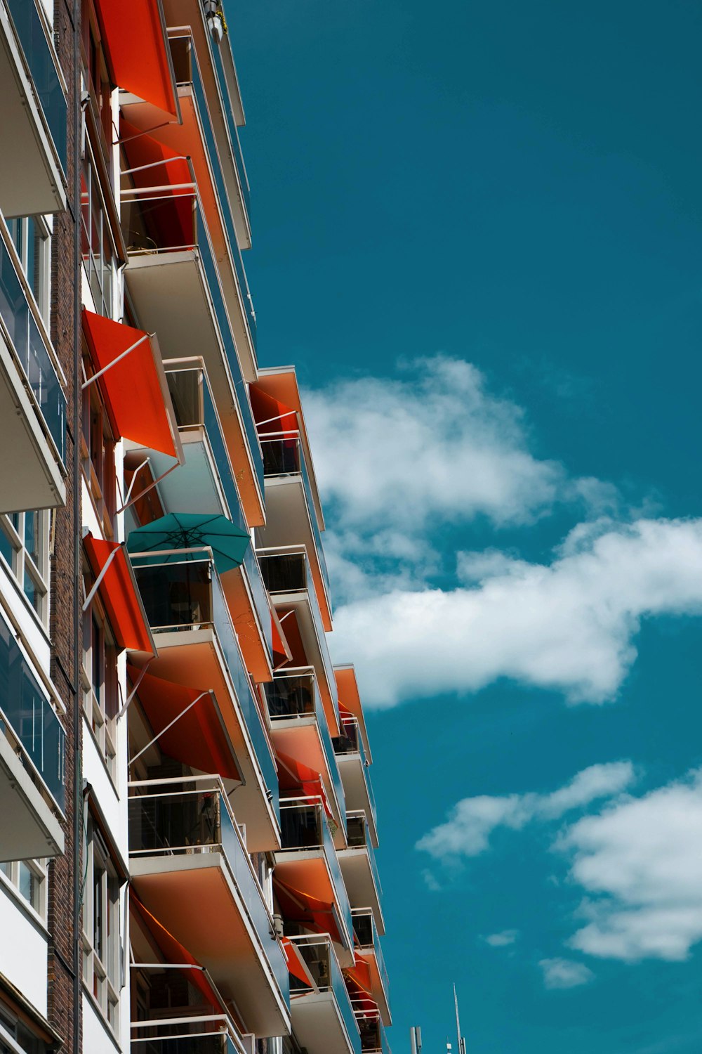 Edificio de hormigón blanco y naranja bajo el cielo azul durante el día