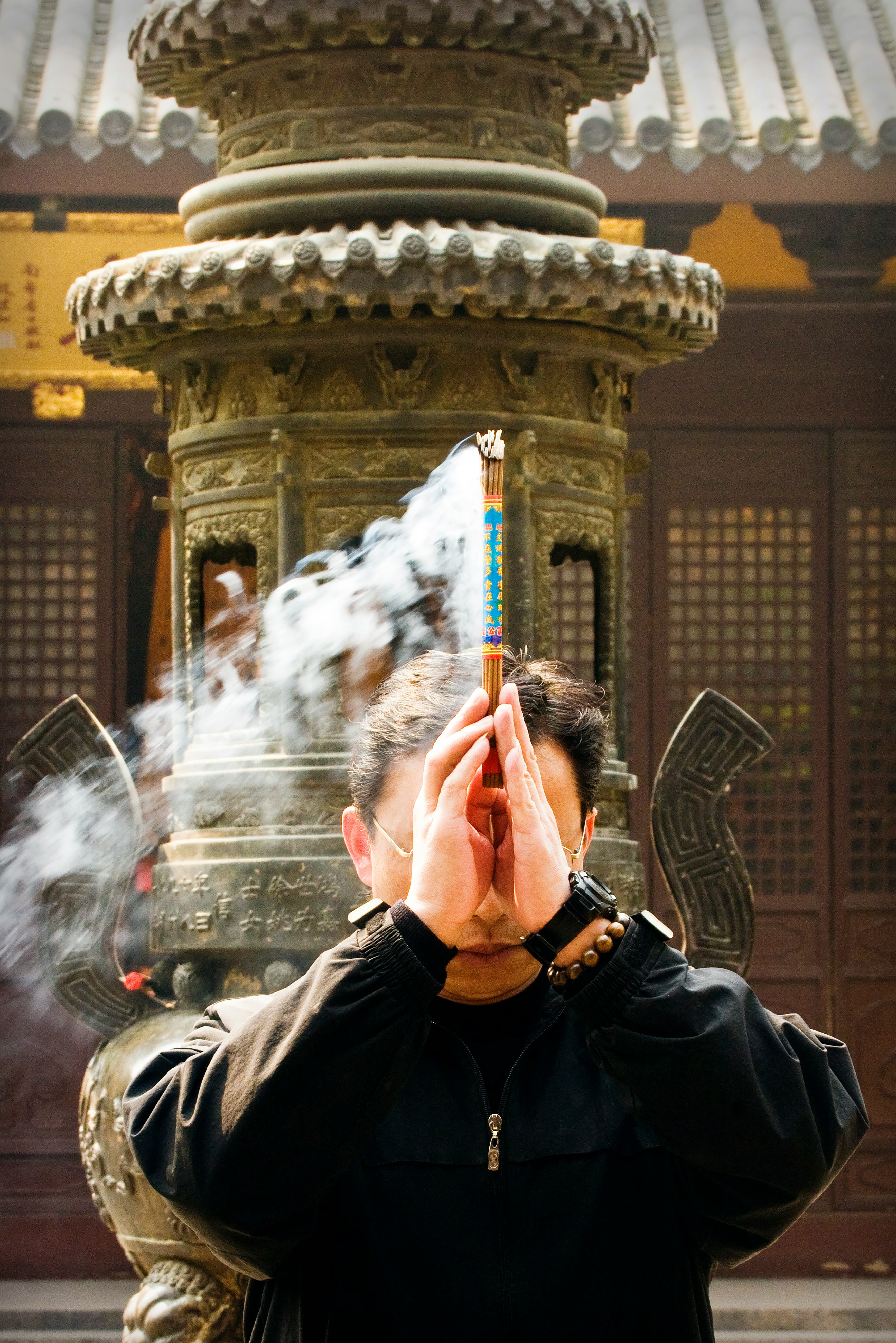 man in black jacket holding red and white powder