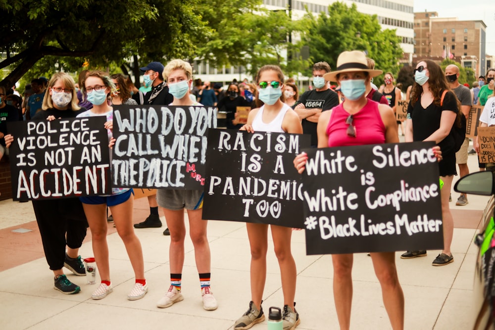 group of women holding black and white banner